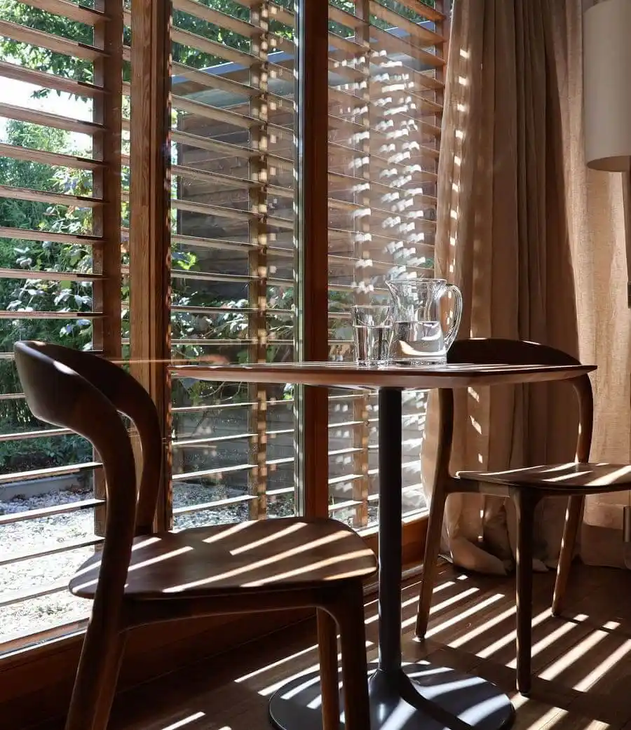 Gästezimmer der Naturunterkunft mit Sitzbereich am Fenster und Gartenblick